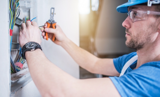 Electric Technician Job. Caucasian Professional Electrician in His 30s Finishing Electric Box Inside the Apartment.